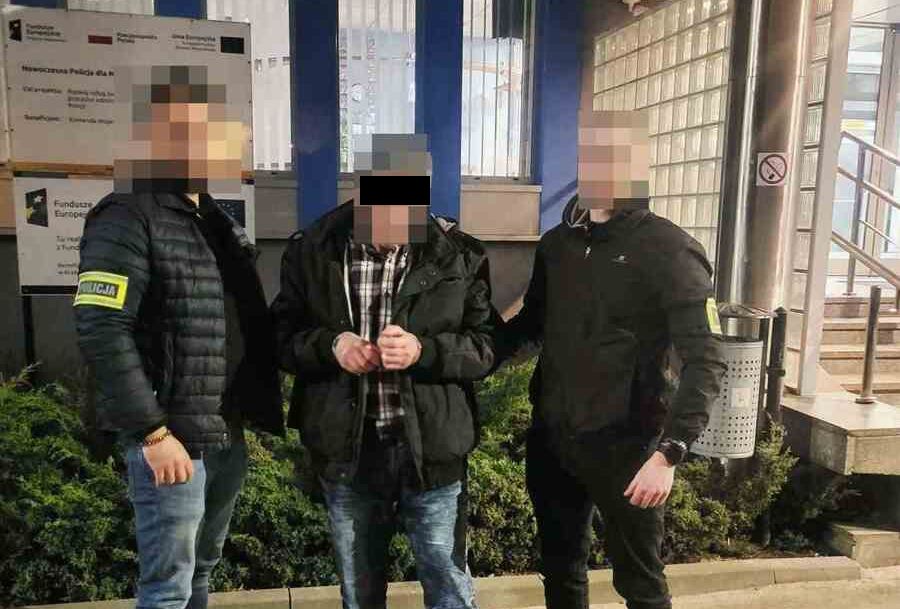 Policjanci prowadzą zatrzymanego mężczyznę.