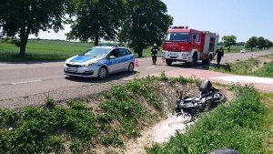 miejsce zdarzenia przedstawiające motocykl w rowie oraz radiowo i straż pożarną