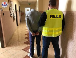 zatrzymany mężczyzna doprowadzany przez policjanta