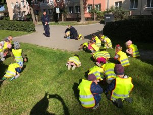 policjanci pokazujący dzieciom bezpieczna pozycję podczas ataku psa