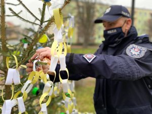 policjant wieszający odblask na choince