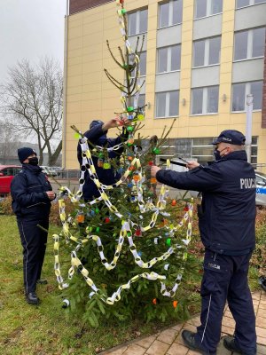 policjant wieszający odblask na choince