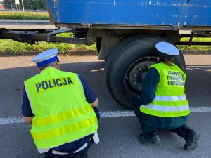 funkcjonariusze sprawdzający koło ciężarówki