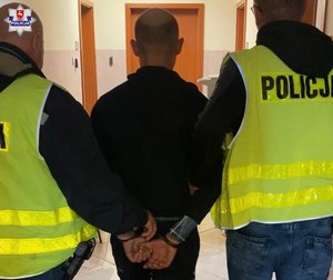 doprowadzany mężczyzna przez dwóch policjantów