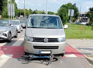 zdjęcie przedstawia pojazd marki VW, który najechał na rower, ulicę z miejsca zdarzenia, w tle inne pojazdy