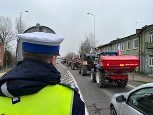 policjant i ciągniki podczas protestu rolników