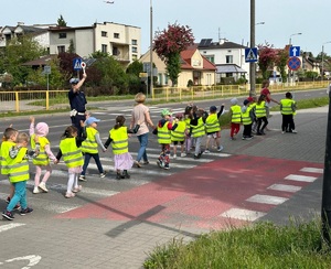 policjant uczy dzieci przechodzenia po przejściu dla pieszych