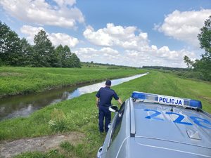 strażacy i policjanci kontrolujący teren nadrzeczny