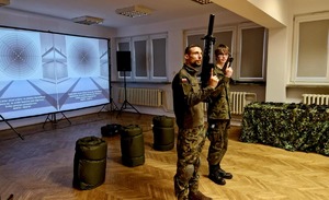 uczniowie na strzelnicy prezentujący broń