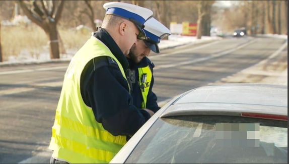 policjanci przeprowadzający kontrolę drogową
