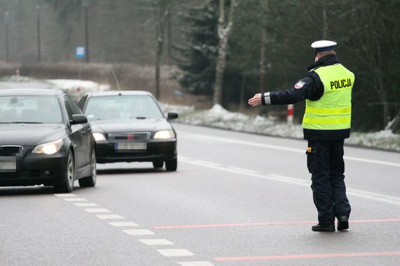 policjant zatrzymujący do kontroli drogowej auto