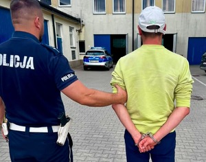 policjant z zatrzymanym mężczyzną