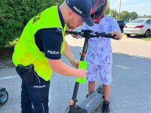 policjant wręczający odblask