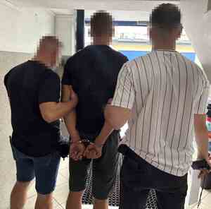 policjanci prowadzą zatrzymanego