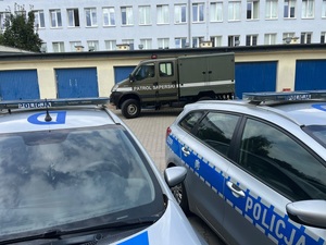 dwa radiowozy policyjne, za nimi pojazd służbowy z napisem patrol saperski